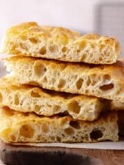 Schiacciata bread recipe sliced and sitting on a cutting board featured photo.