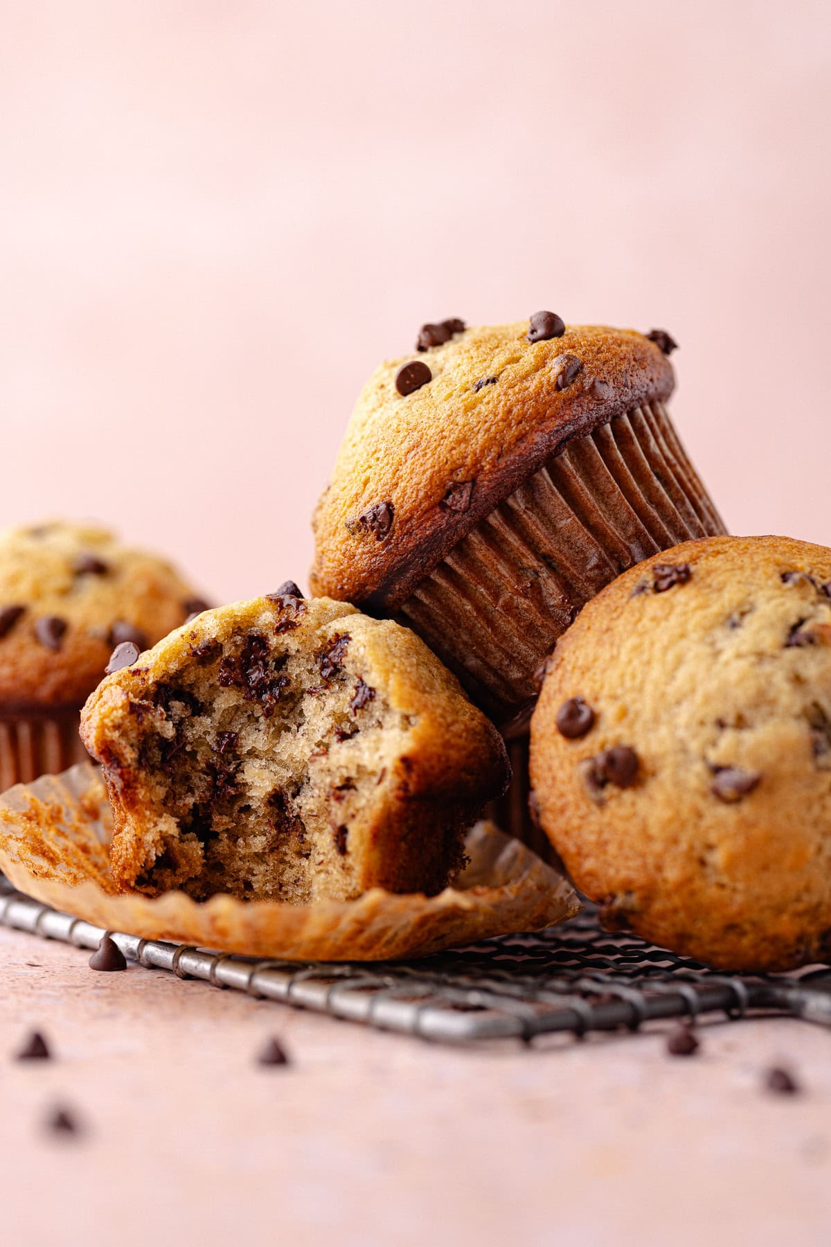 A small batch of chocolate chip banana muffins on a wire rack.