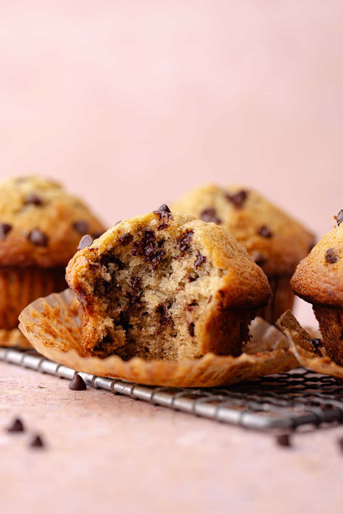 A small batch of chocolate chip banana muffins on a wire rack.