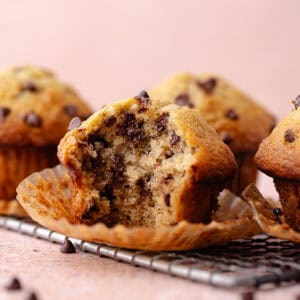 A small batch of chocolate chip banana muffins on a wire rack feature photo.