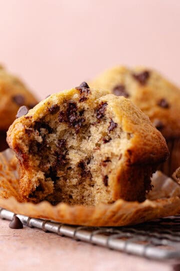 A small batch of chocolate chip banana muffins on a wire rack feature photo.