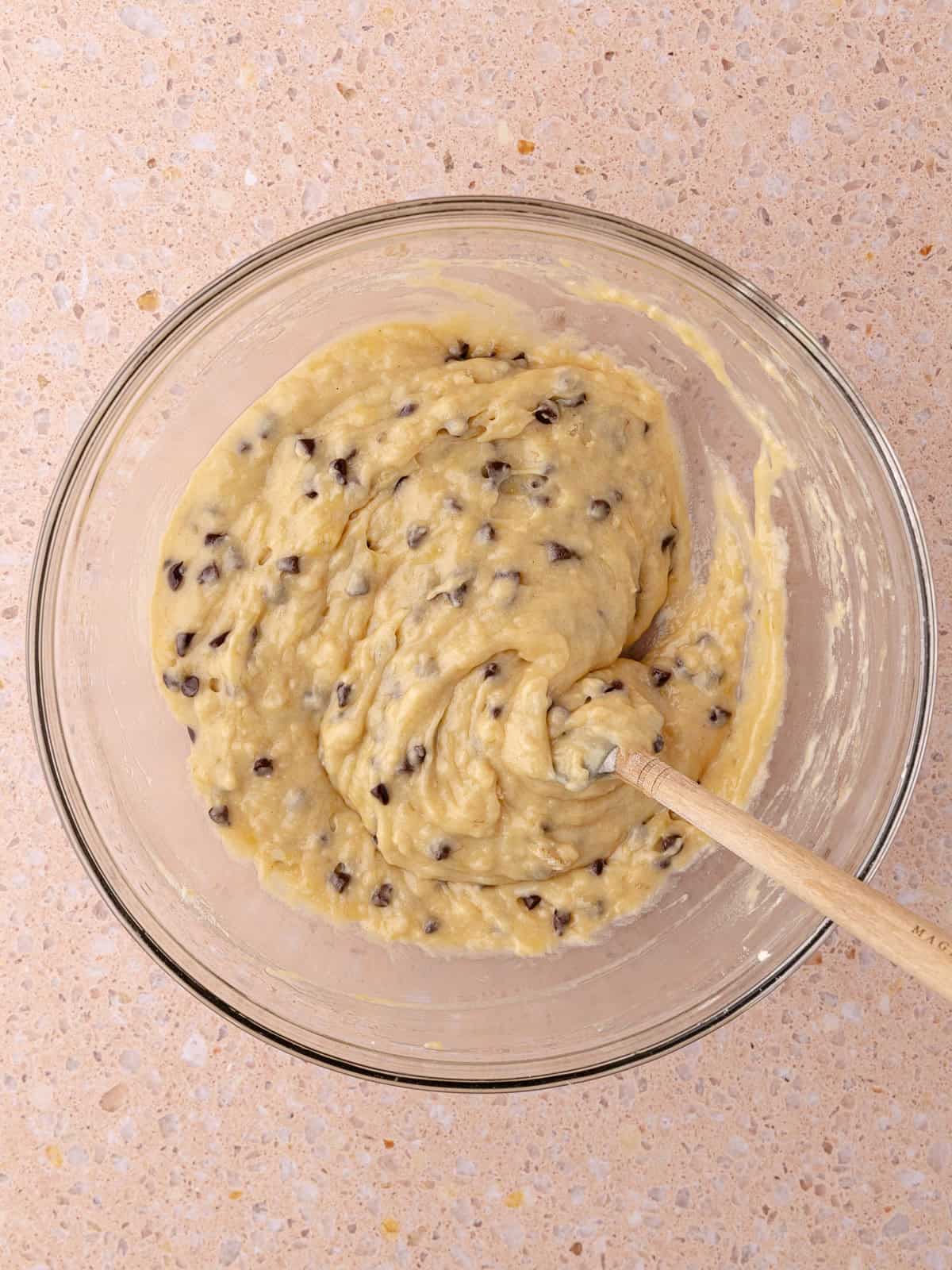 Chocolate chip Banana muffin batter is in a glass mixing bowl.