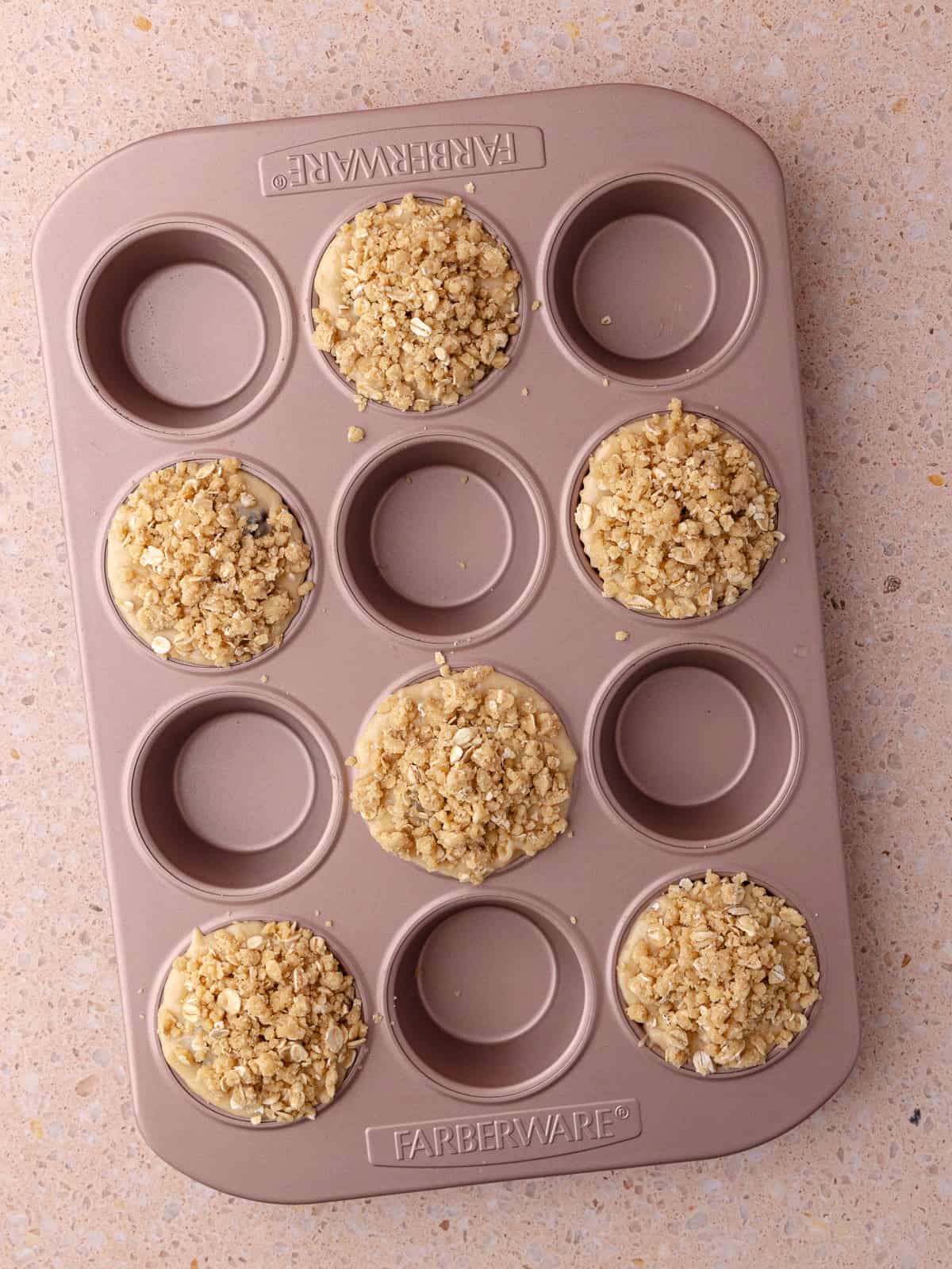 Oatmeal streusel topping is added on top of the banana blackberry muffin batter.