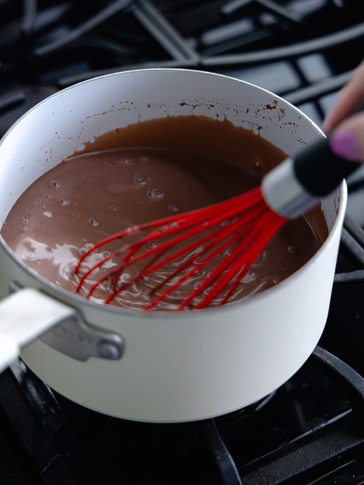 Tempered chocolate ice cream base is simmering in a small saucepan.