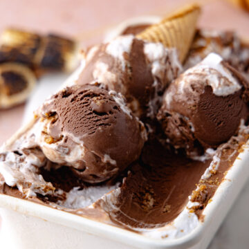 Close up of scoops of chocolate s'mores ice cream in a white container feature photo.