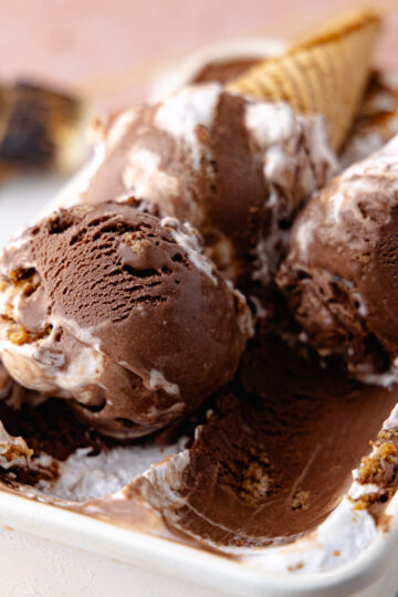 Close up of scoops of chocolate s'mores ice cream in a white container feature photo.