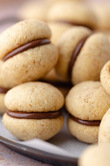 Baci di dama cookies (hazelnut sandwich cookies) are on a serving platter featured photo.