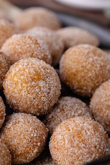 Baked chai donut holes coated in cinnamon sugar are sitting in a serving tray feature photo.