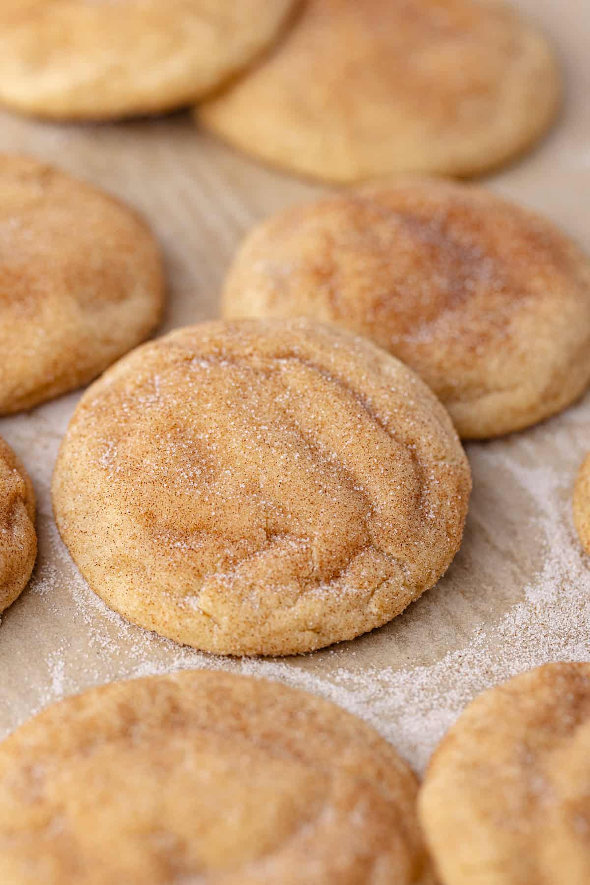 Gooey Biscoff stuffed snickerdoodle cookies sitting on a baking sheet.