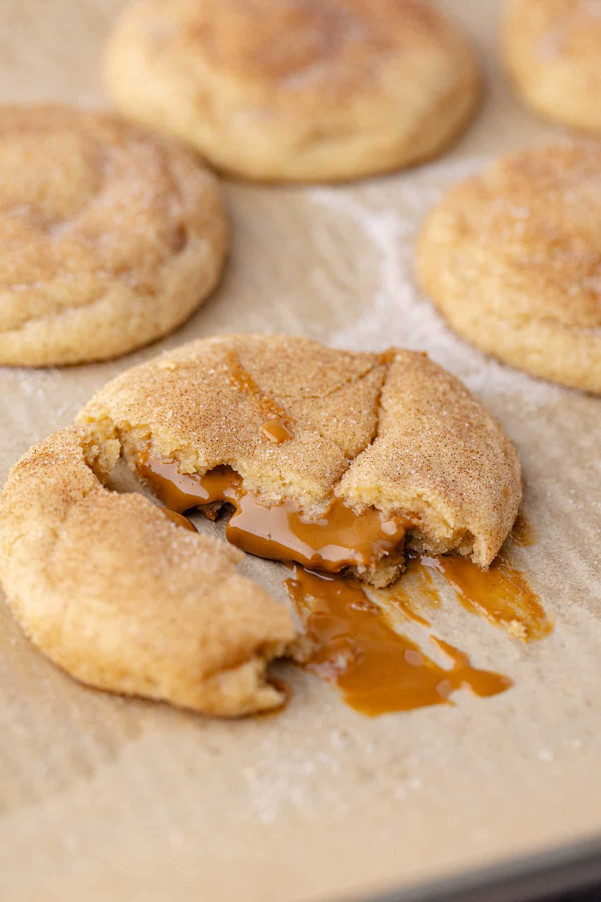 Gooey Biscoff stuffed snickerdoodle cookies sitting on a baking sheet.