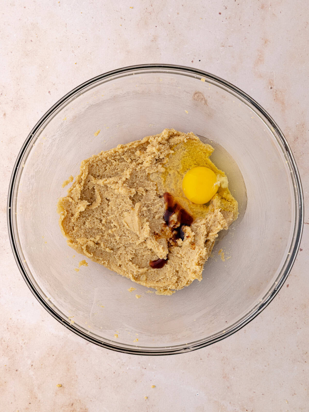 Egg and vanilla are added to the bowl with the butter and sugar mixture.