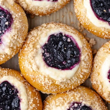 Blueberry cheesecake brioche buns, filled with a cheesecake filling, homemade wild blueberry jam, and then baked with a streusel topping feature photo.