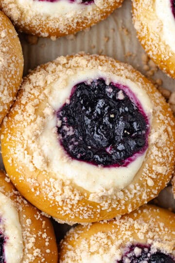 Blueberry cheesecake brioche buns, filled with a cheesecake filling, homemade wild blueberry jam, and then baked with a streusel topping feature photo.