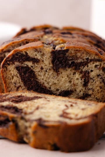 Chocolate marbled banana bread slices sitting on a wire rack featured photo.