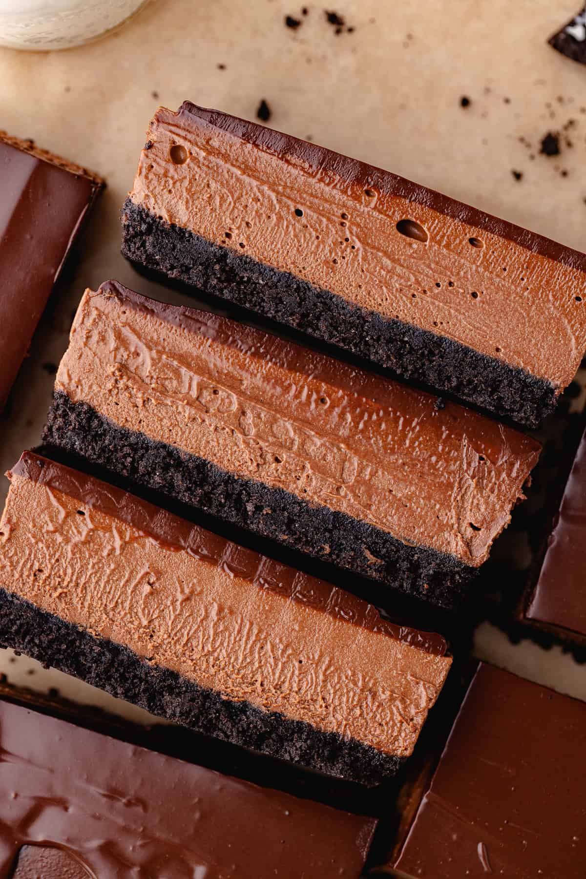 No bake chocolate mousse bars with an oreo cookie crust and chocolate ganache are sliced into bars.