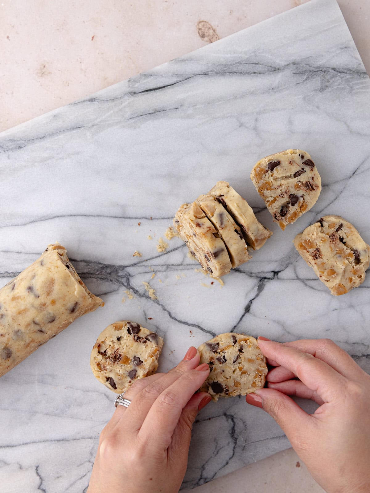 Soft and tender shortbread cookies with dark chocolate chips and homemade toffee bits sliced into round discs.