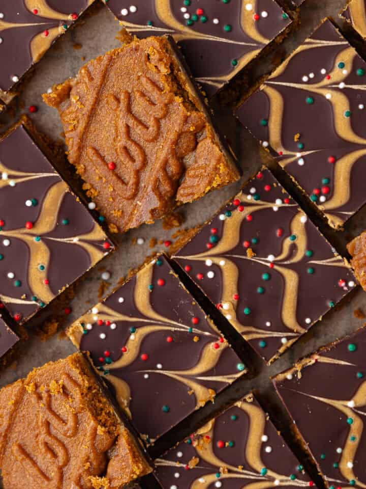 Biscoff toffee candy, also known as Biscoff Christmas crack, is layered with Biscoff cookies, salted toffee, dark chocolate, Biscoff cookie butter and Christmas sprinkles and cut into small squares.