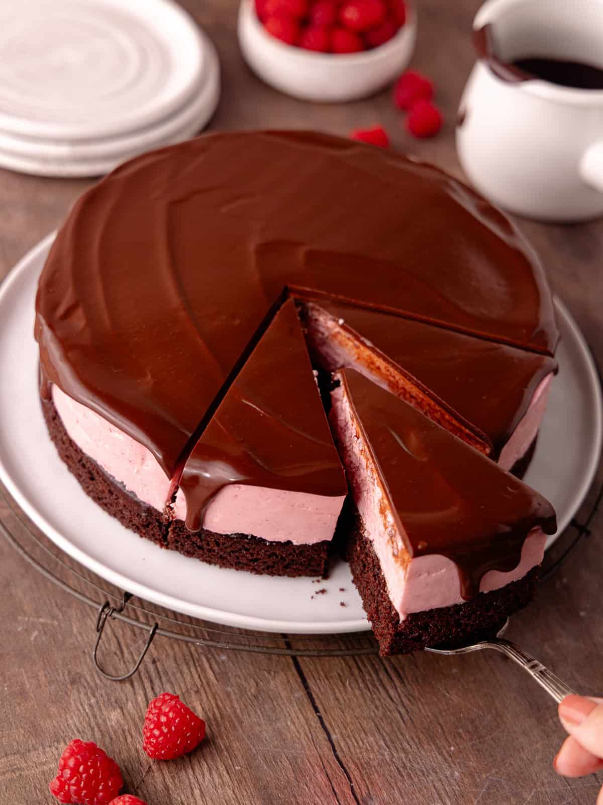 Raspberry white chocolate mousse cake features a moist dark chocolate cake base, followed by a raspberry white chocolate mousse that's made without gelatin or eggs, and finished with a chocolate ganache.