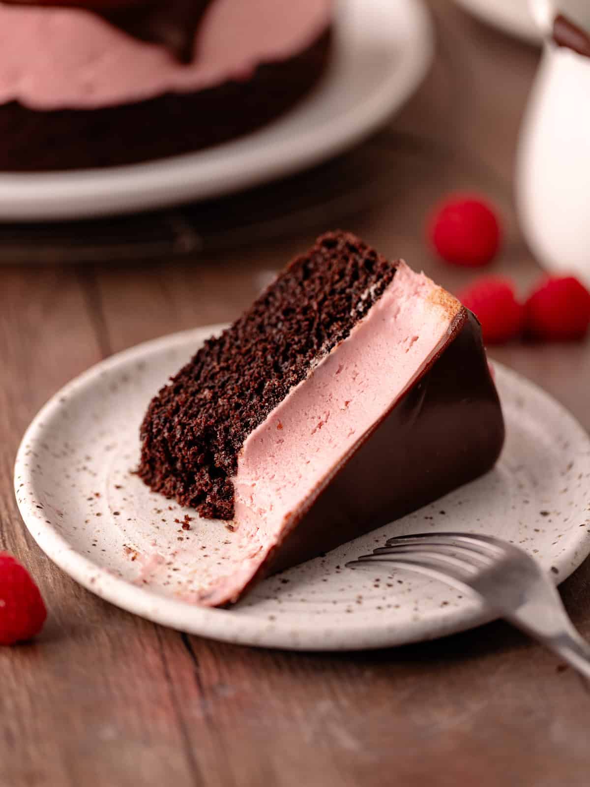 Raspberry white chocolate mousse cake features a moist dark chocolate cake base, followed by a raspberry white chocolate mousse that's made without gelatin or eggs, and finished with a chocolate ganache.