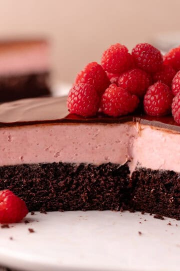 Raspberry white chocolate mousse cake features a dark chocolate cake base, followed by a raspberry white chocolate mousse that's made without gelatin or eggs, and finished with a chocolate ganache.