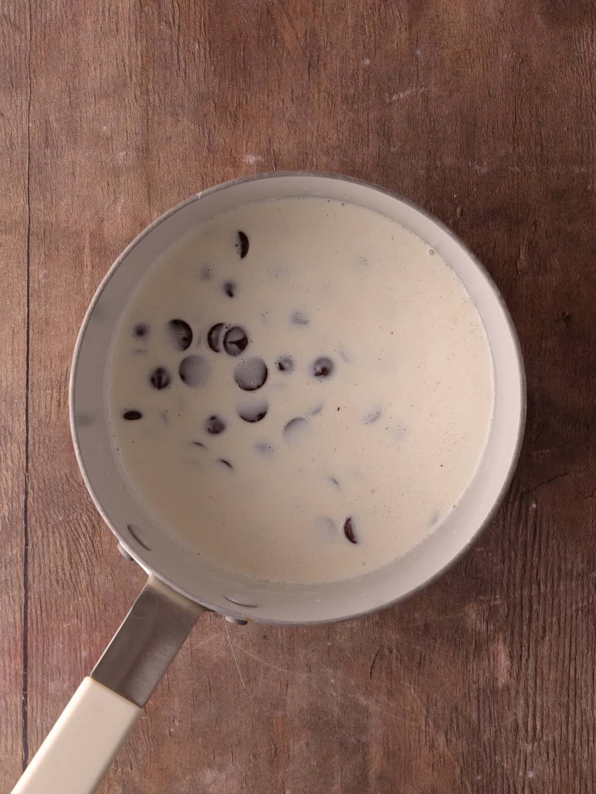Hot cream and chocolate chips are in a small pot.