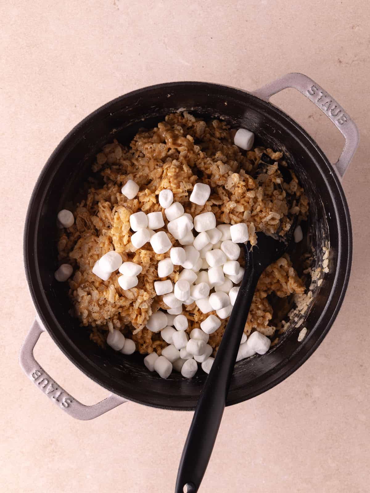 Mini marshmallows are added to the pot of cookies butter rice krispie treats.