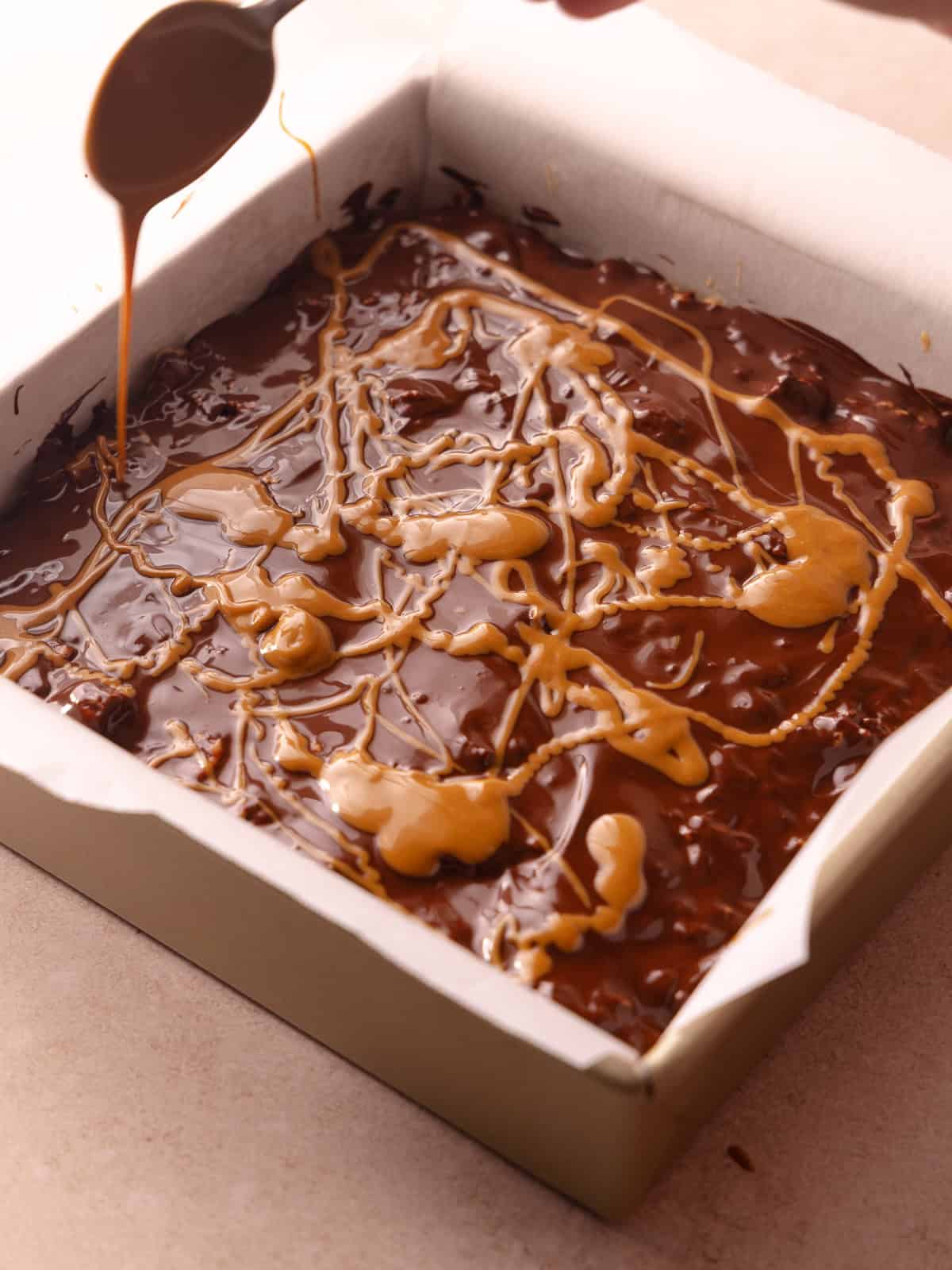 Melted chocolate and melted cookie butter is swirled together on top of the Biscoff rice krispie treats.