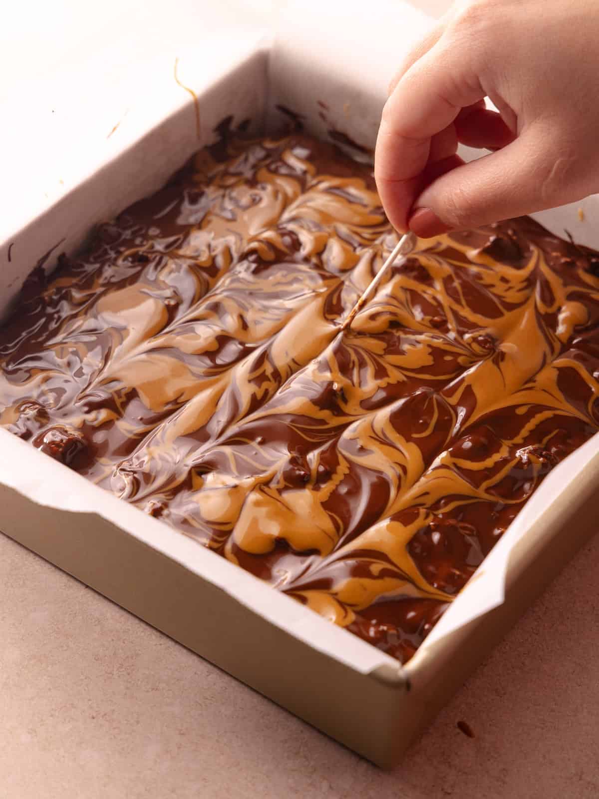 Melted chocolate and melted cookie butter is swirled together on top of the Biscoff rice krispie treats.