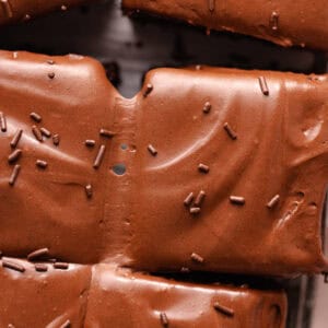 Soft and moist chocolate malted cake is topped with chocolate malted frosting and chocolate sprinkles.