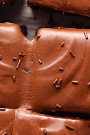 Soft and moist chocolate malted cake is topped with chocolate malted frosting and chocolate sprinkles.