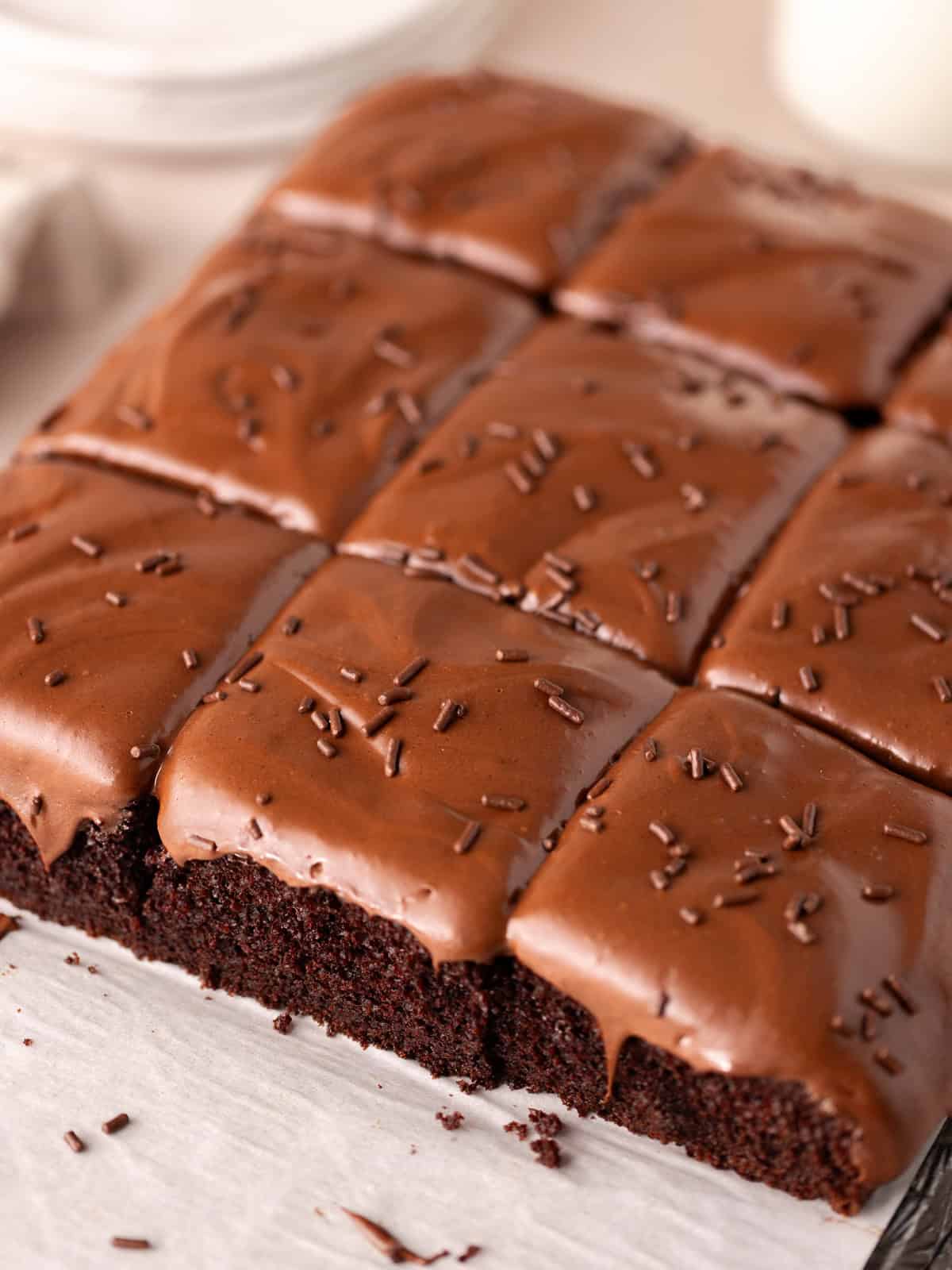 Soft and moist chocolate malted cake is topped with chocolate malted frosting and chocolate sprinkles.