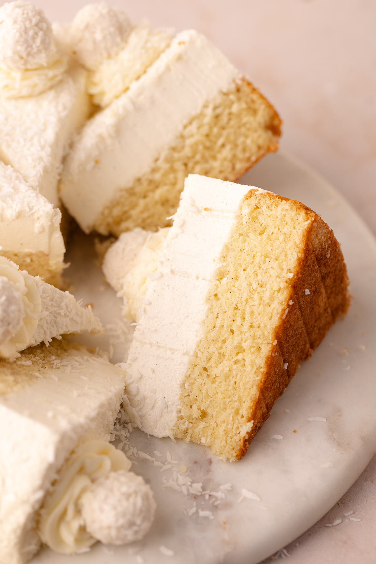 Dreamy coconut mousse cake featuring a super moist coconut cake base, layered with a light and creamy coconut mousse, shredded coconut and Raffaello candy!