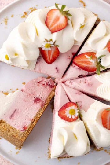 No bake strawberry pretzel cheesecake decorated with whipped cream and strawberries are sliced on a serving plate feature photo.