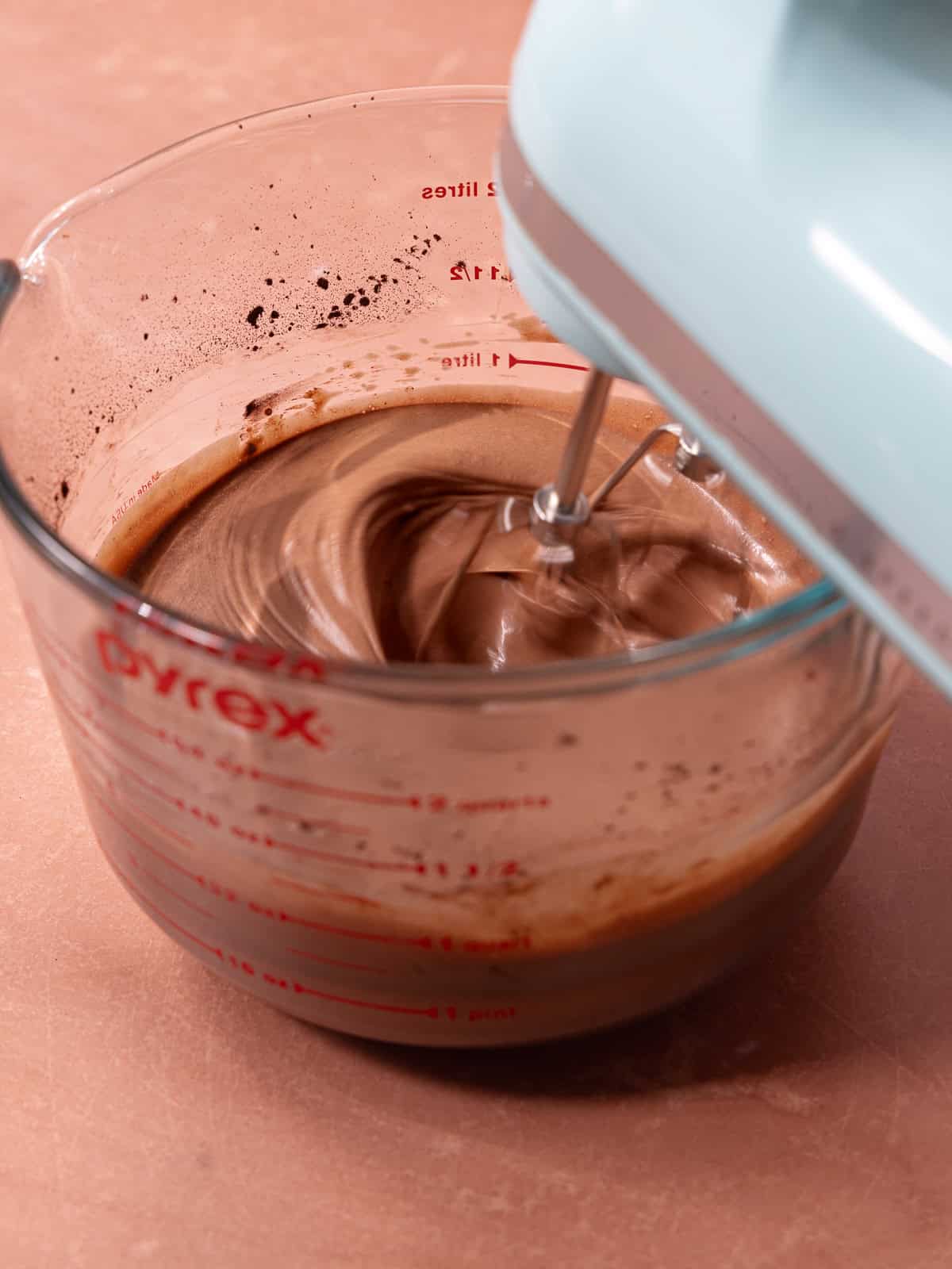 Cold coconut milk, condensed milk, cocoa powder, espresso powder and vanilla whipped together until combined in a glass mixing bowl.