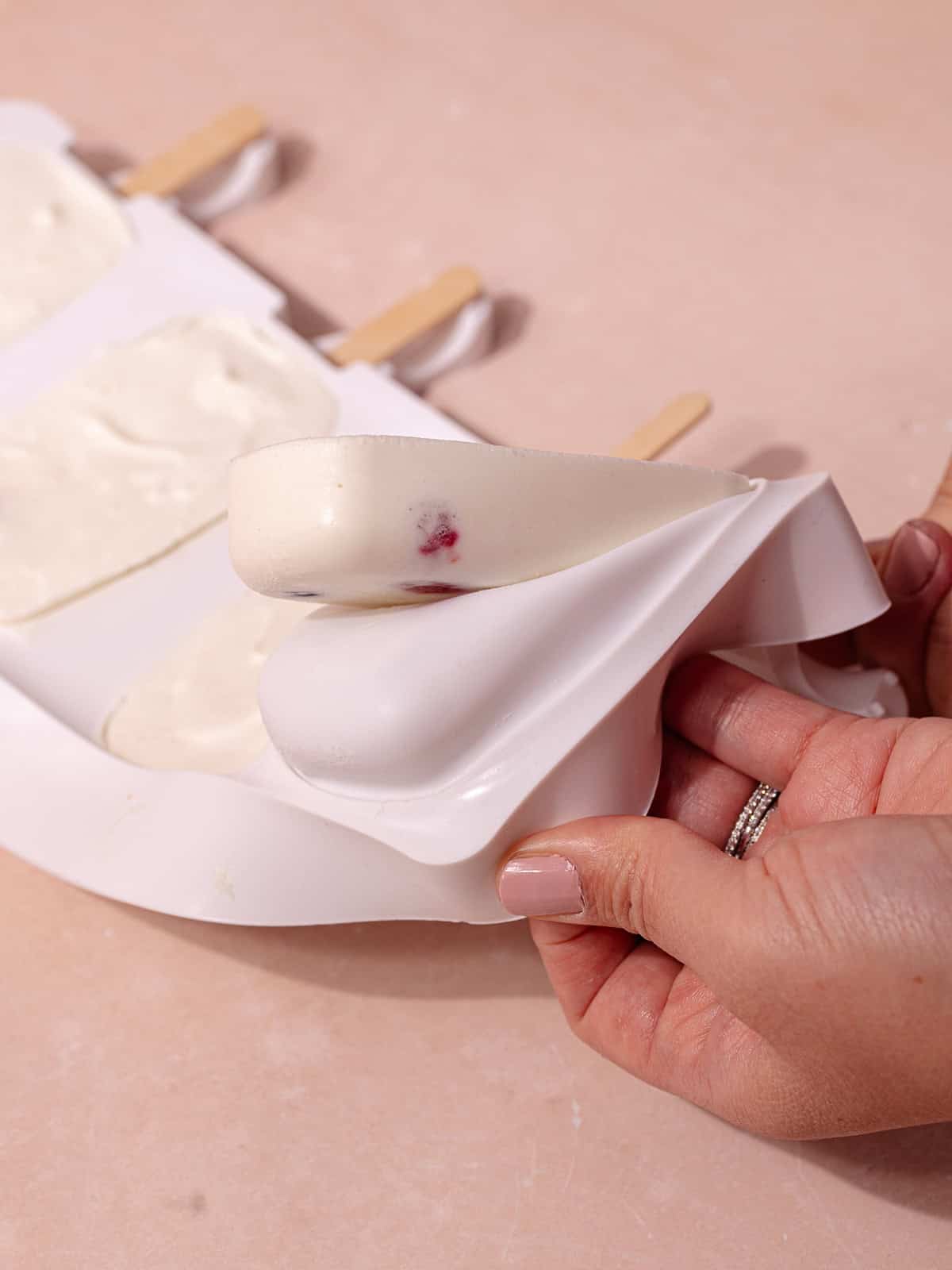 The creamy coconut popsicles are unmolded from the silicone popsicle molds.