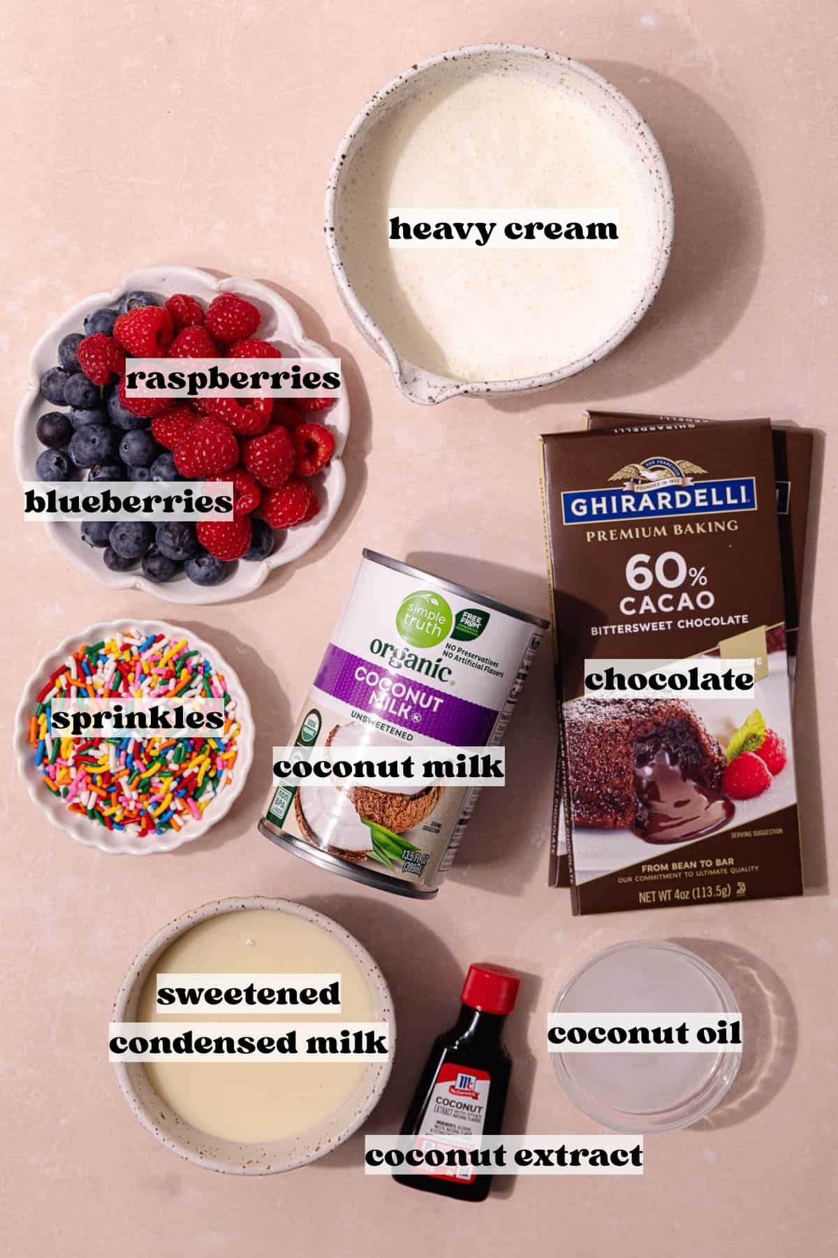 Creamy coconut popsicles with fresh raspberries and blueberries are dipped in a magic chocolate shell and topped with rainbow sprinkles. The ingredients include, canned coconut milk, heavy cream, sweetened condensed milk, coconut extract, fresh raspberries, fresh blueberries, chocolate bars, coconut oil and rainbow sprinkles.