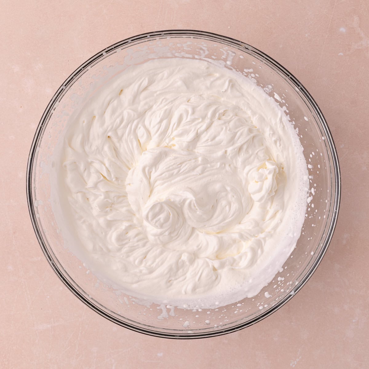 Cold heavy cream and salt is whipped in a large mixing bowl with an electric mixer until firm.