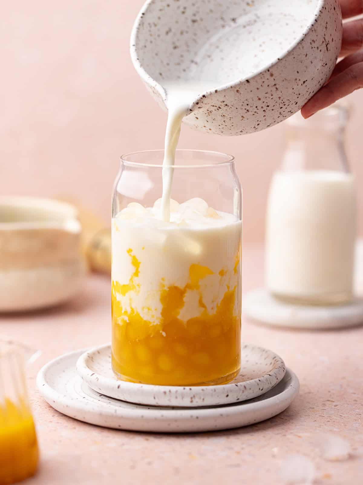 Ice and milk is added over the peach puree and homemade peach boba pearls.