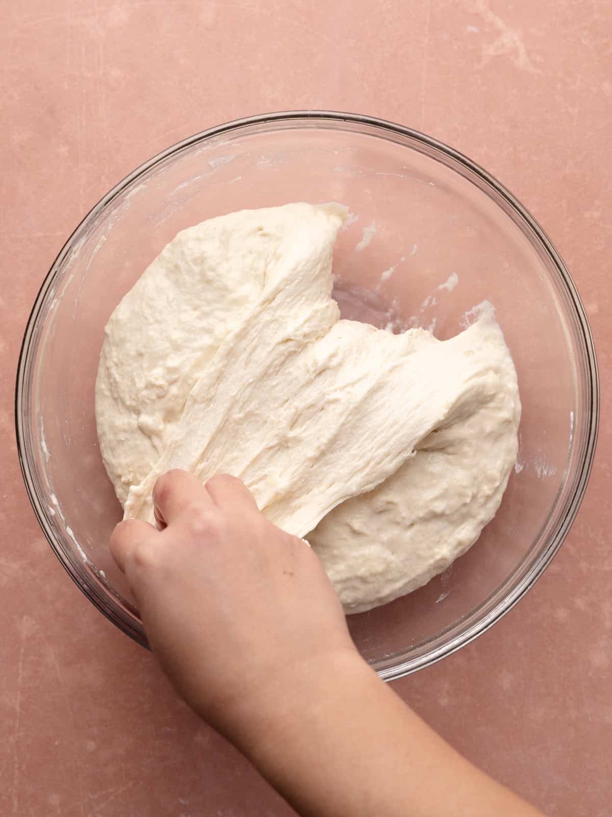 The focaccia dough is folded on top of itself.