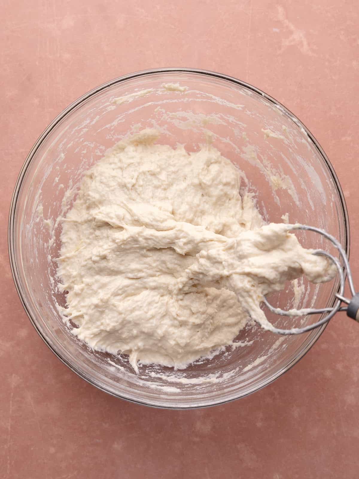 Bread flour is added to the water yeast mixture and mixed together until combined into a shaggy dough.