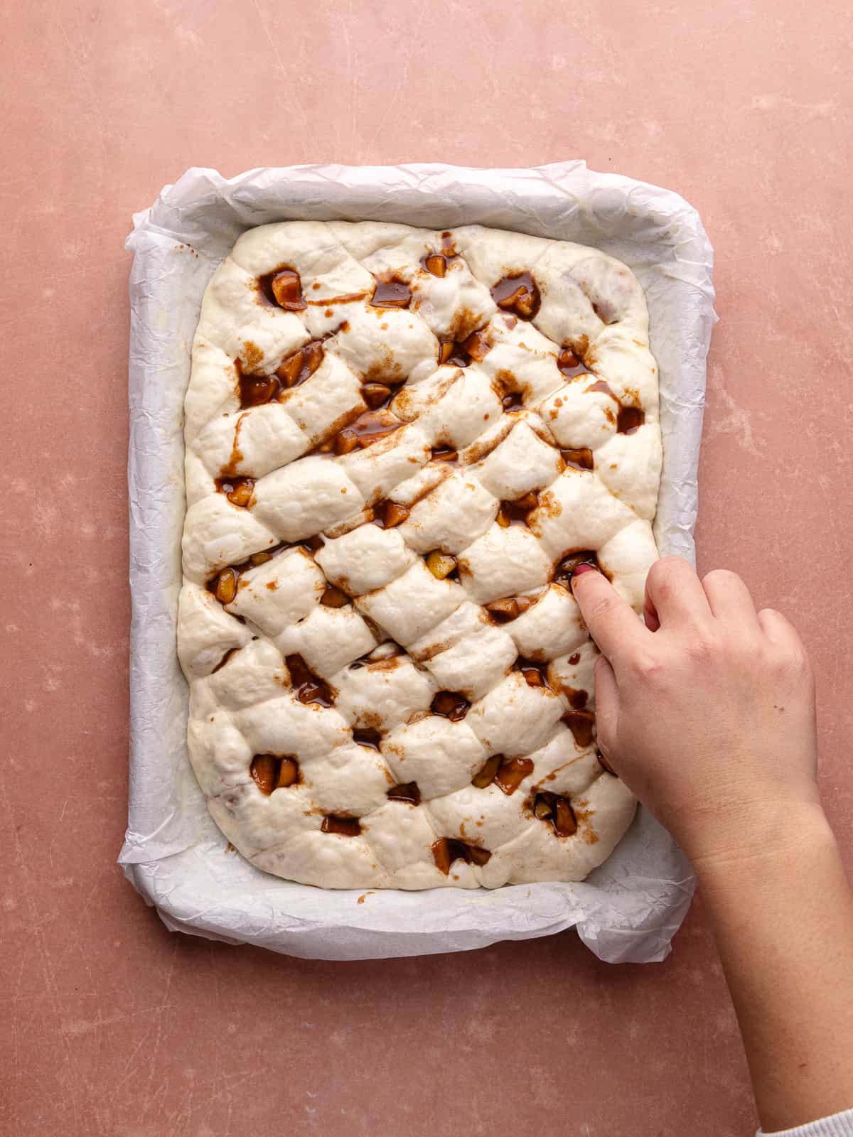 Addition apples are pressed into the cracks of the apple fritter focaccia loaf.
