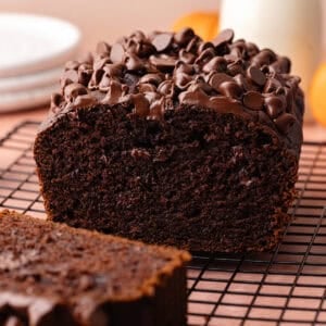 Super moist chocolate pumpkin bread studded with chocolate chips is sliced and sitting on a wire rack feature photo.