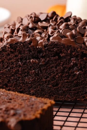 Super moist chocolate pumpkin bread studded with chocolate chips is sliced and sitting on a wire rack feature photo.