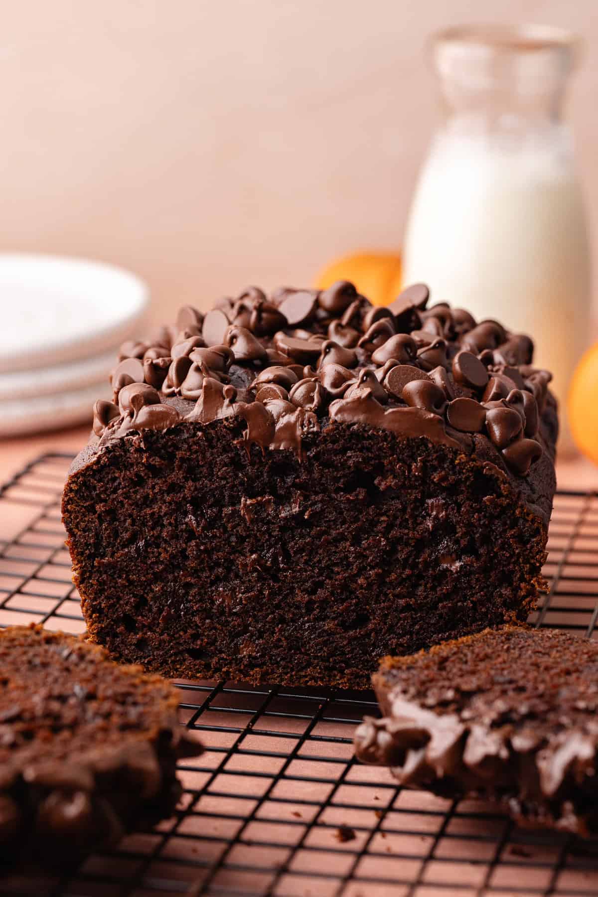 Super moist chocolate pumpkin bread studded with chocolate chips is sliced and sitting on a wire rack.
