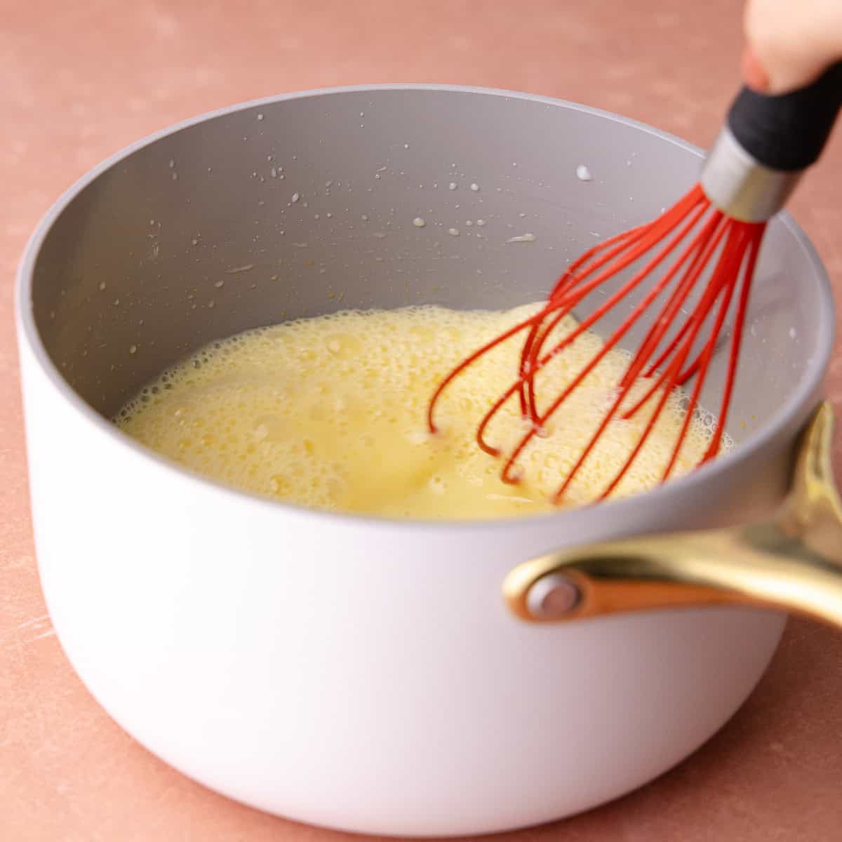 Egg yolks are whisked together with the milk, sugar, and cornstarch mixture.