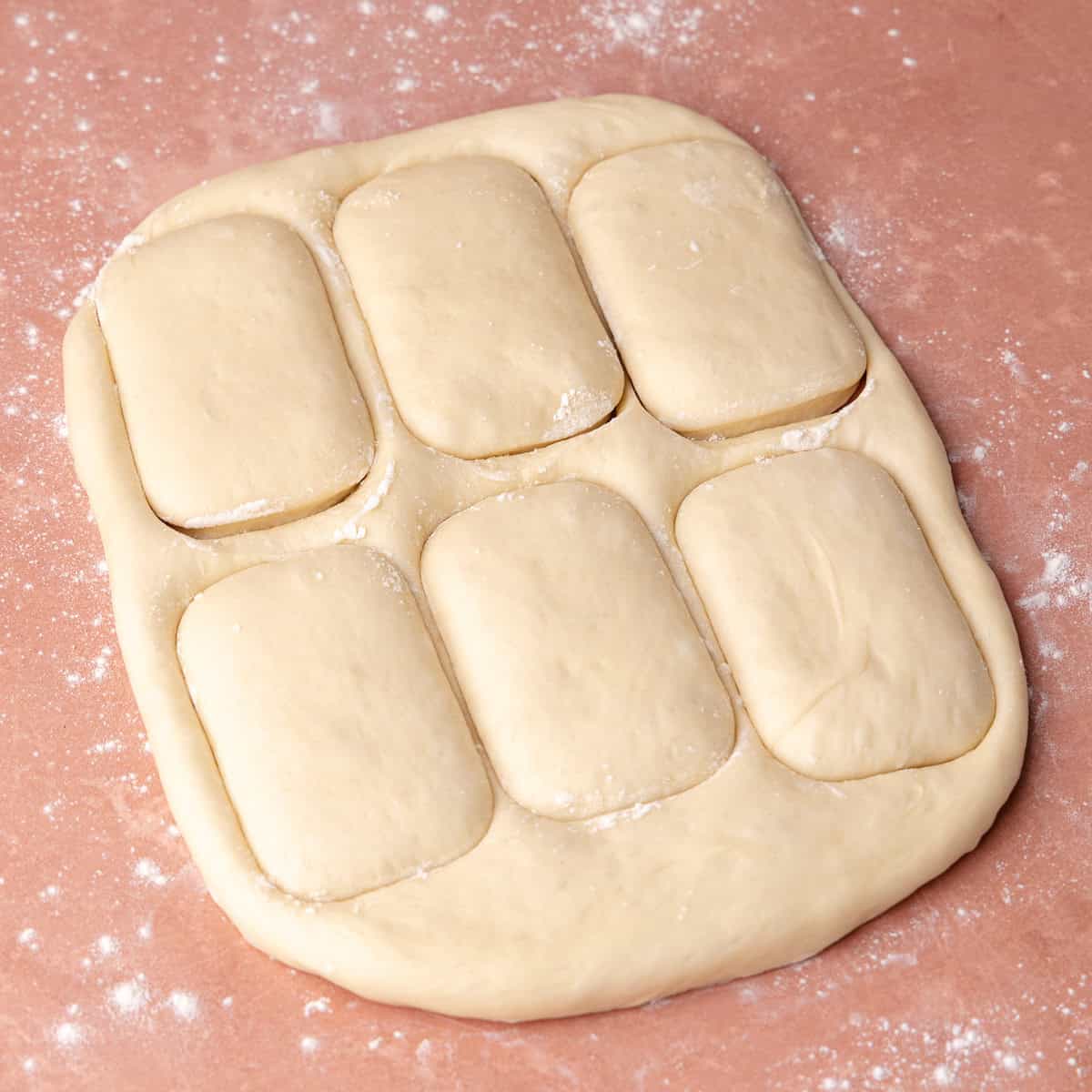 Milk bread donut dough is cut into bars.