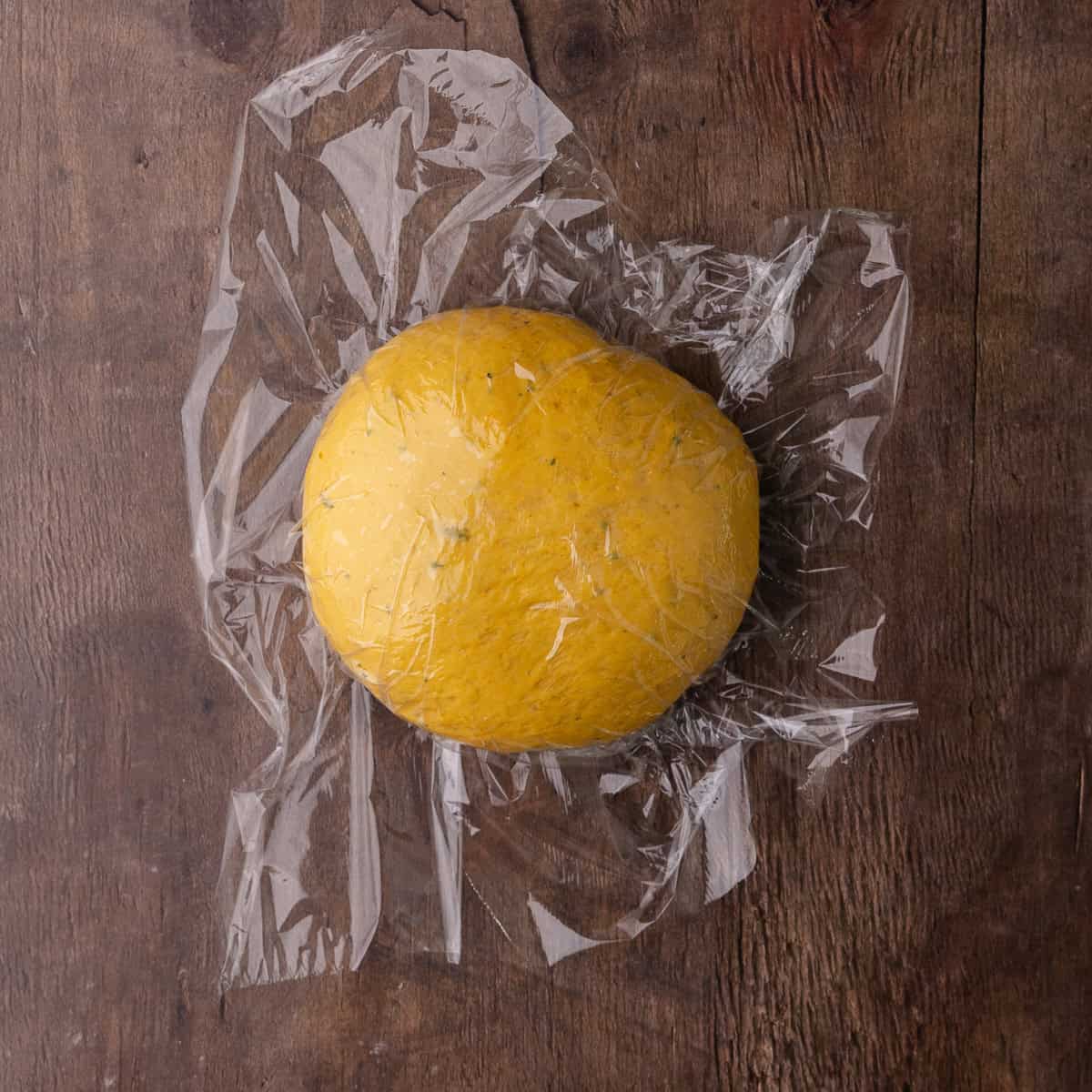 Soft pumpkin sage dough is kneaded into a smooth ball.