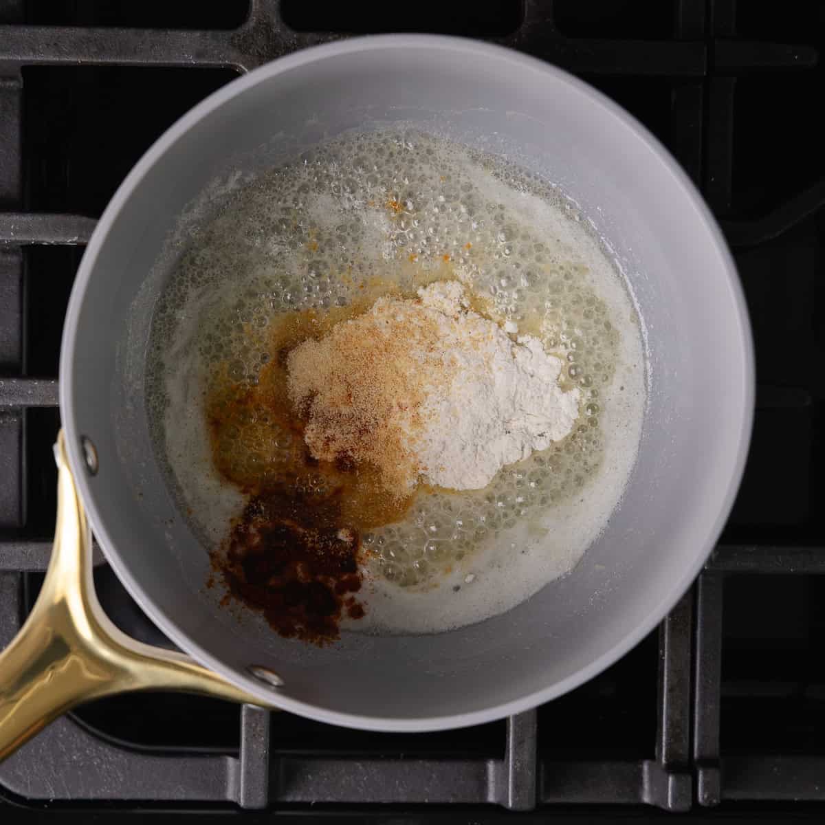 Melted butter, flour, onion powder, garlic powder, and smoked paprika is cooked together in a small saucepan.