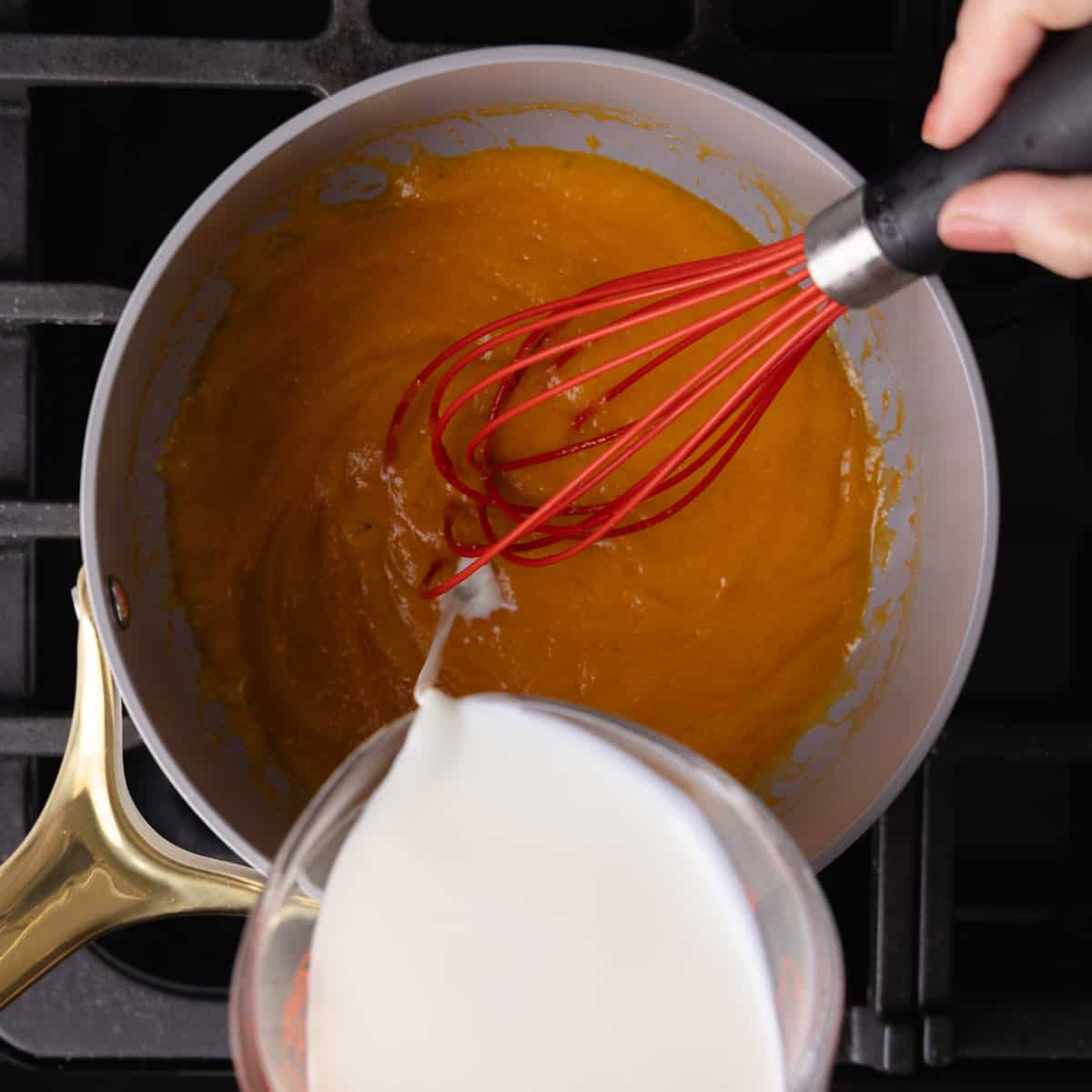 Milk is slowly drizzled into the beer roux mixture.