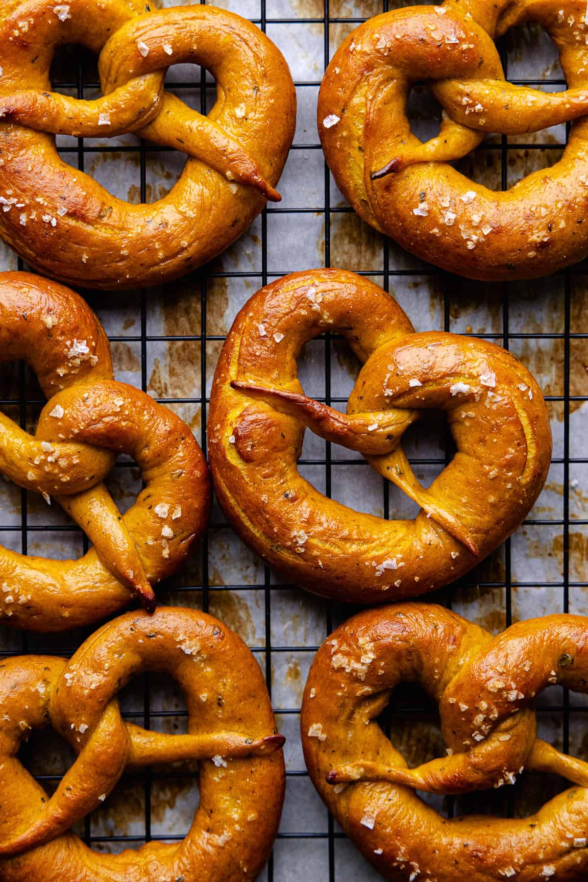 Soft pumpkin sage pretzels are topped with flaky sea salt and baked until golden brown and shiny.